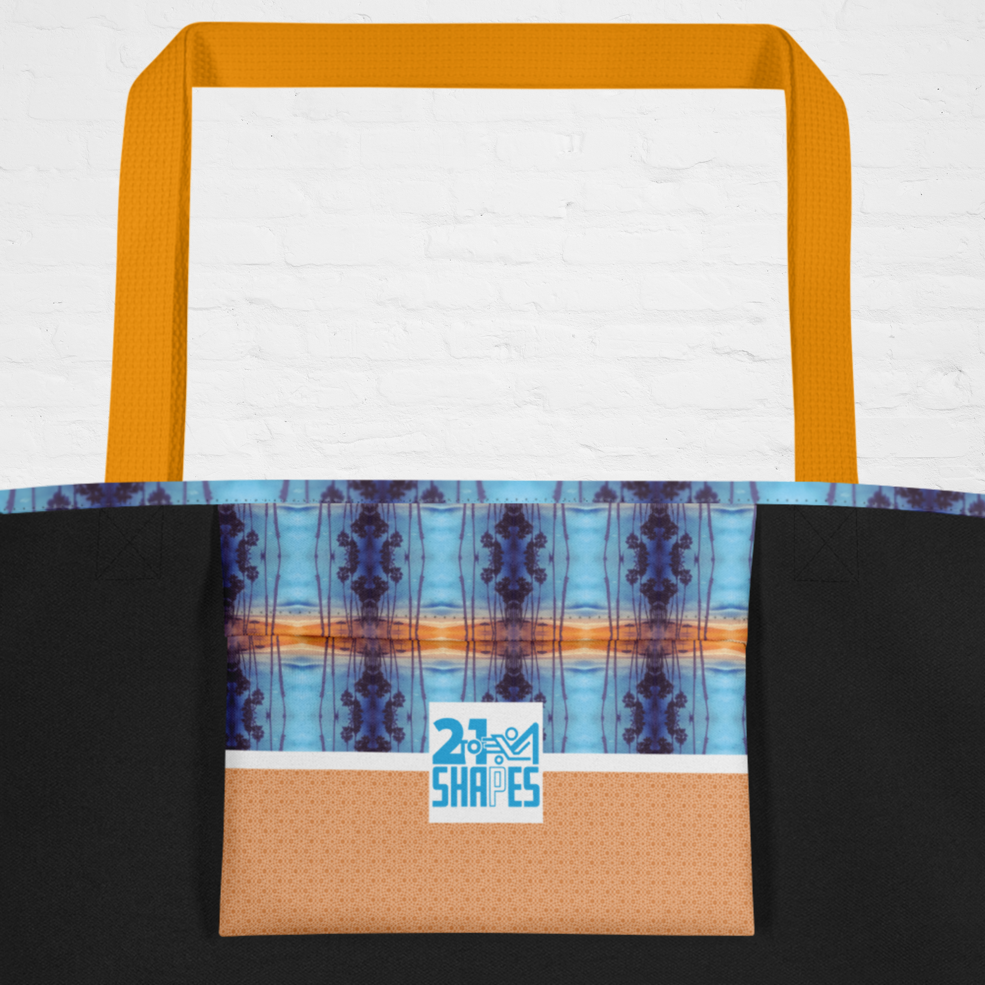 Tote bag inside pocket with blue, and orange geometric pattern with the 2-to-1 Shapes brand logo on a white background
